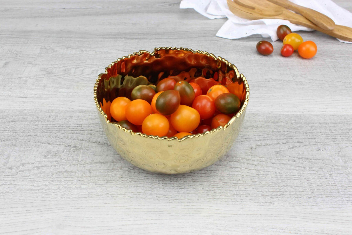 Pampa Bay Golden Millennium medium bowl in hammered gold porcelain on a table with cherry tomatoes inside
